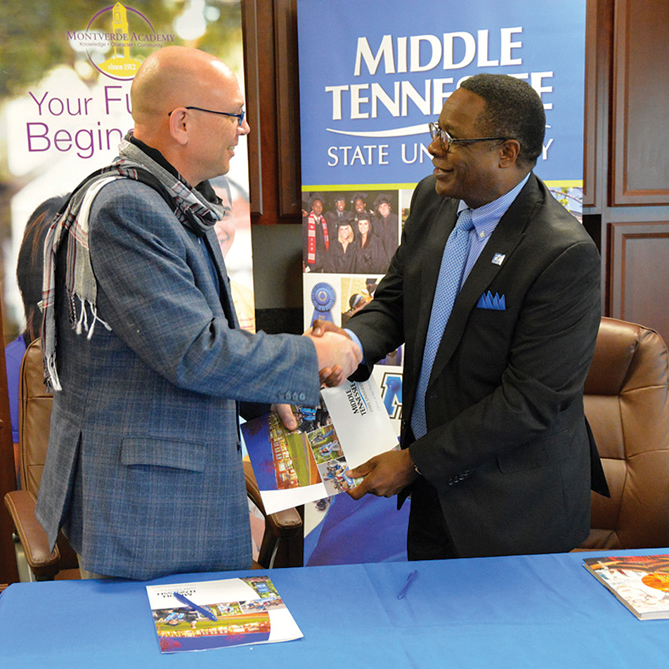 Montverde Headmaster Kasey Kesselring (left) and MTSU President Sidney A. McPhee shake hands Friday after signing a pact that will allow for dual enrollment of Montverde students, most likely through online classes by the university. (MTSU photo by Andrew Oppmann)