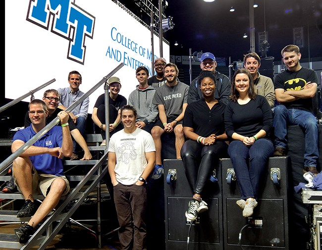 Mike Forbes, seated at front left, assistant director of technologies for MTSU's College of Media and Entertainment, is joined by his Video Technology class students on stage in Murphy Center early Oct. 1 in front of the customized 30-foot-by-20-foot video wall they created for the Homecoming 2015 concert featuring Icona Pop. Shown on the front row with Forbes are senior electronic media communication majors Paul Douglas, Angie Carter and Adrienne Kelley. Seated on the stairs and in the second row are, from left, junior EMC majors Zack Johnson, Barrett Depies and Sara Daily; senior EMC majors David Marrow and Robbie Weaver; junior EMC major Sokoya Crockett; seniors Wes Jenkins and Trevor Ball and junior Alex Briley. (MTSU photo by News and Media Relations)