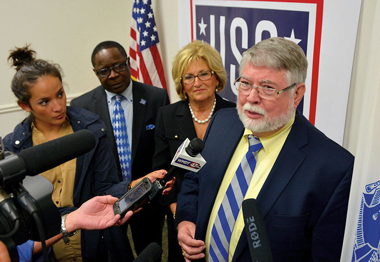 Middle Tennessee State University forensics professor Hugh Berryman speaks to media Wednesday, Sept. 28, during a press conference at Dover Air Force Base in Delaware about the return of soldier remains from the Mexican-American War. Standing behind him are U.S. Rep. Diane Black and MTSU President Sidney A. McPhee. (MTSU photo by Andrew Oppmann)